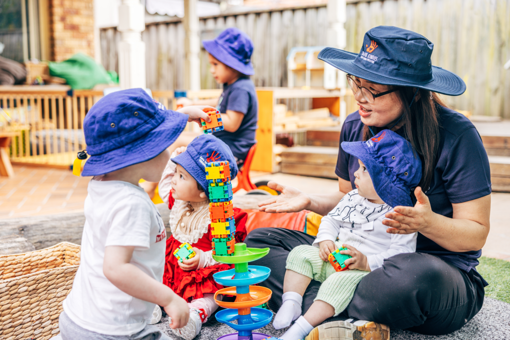 Miss Mikki playing with the children in the garden at Care for Kindies, Seymour Parade.